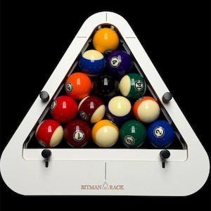 Könnte beinhalten: Ein vollständiger Satz Billardkugeln, angeordnet in einem Dreieck in einem weißen Rack, spielbereit. Die Kugeln sind nummeriert und farbig, mit schwarzem Hintergrund. Auf dem Rack steht der Text "BITMAN RACK".