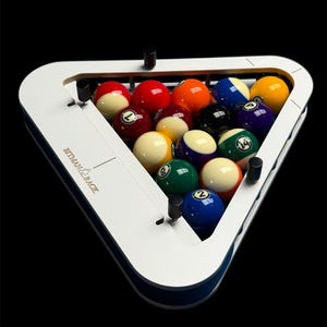 Pode incluir: Um suporte triangular branco para bolas de bilhar com o texto BITMAN RACK impresso na lateral. O suporte contém quinze bolas de bilhar numeradas e coloridas dispostas em pirâmide, com vários designs sólidos e listrados em diversas cores.