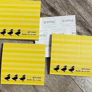 May include: Three yellow Post-it notes with black ducks and the text "get your ducks in a row".