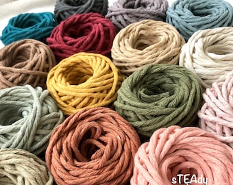 Op de afbeelding: Een verzameling van meerdere bollen gedraaid katoenkoord in diverse kleuren, waaronder teal, bordeaux, mosterdgeel, olijfgroen, terracotta, roze en beige. De tekst sTEAdy decor is in het wit gedrukt op de roze bol met koord.