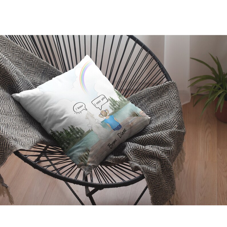 May include: White throw pillow with a watercolor illustration of a girl standing by a lake with a rainbow in the sky. The girl is looking at a white figure with the words "I know" and "I miss you" in speech bubbles. The text "Bronx. Dive" is written at the bottom of the pillow.