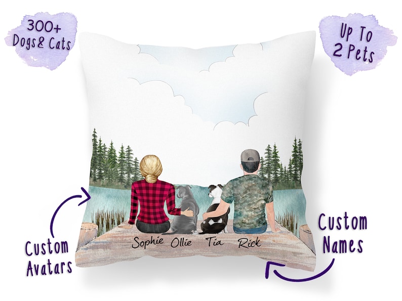 Op de afbeelding: Een gepersonaliseerd kussen met een aquarel-illustratie van een stel en twee honden die op een steiger zitten met uitzicht op een meer. De namen "Sophie", "Ollie", "Tia" en "Rick" staan onder de figuren. Het kussen is aanpasbaar met maximaal 300 verschillende hond- en kat-avatars.