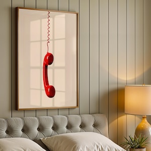 May include: A framed print of a red rotary phone receiver hanging from a coiled cord against a white background.