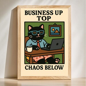 May include: A black cat wearing glasses and a blue shirt sits at a desk with a laptop, a cup of coffee, and a picture frame. The text "Business Up Top Chaos Below" is printed below the image.