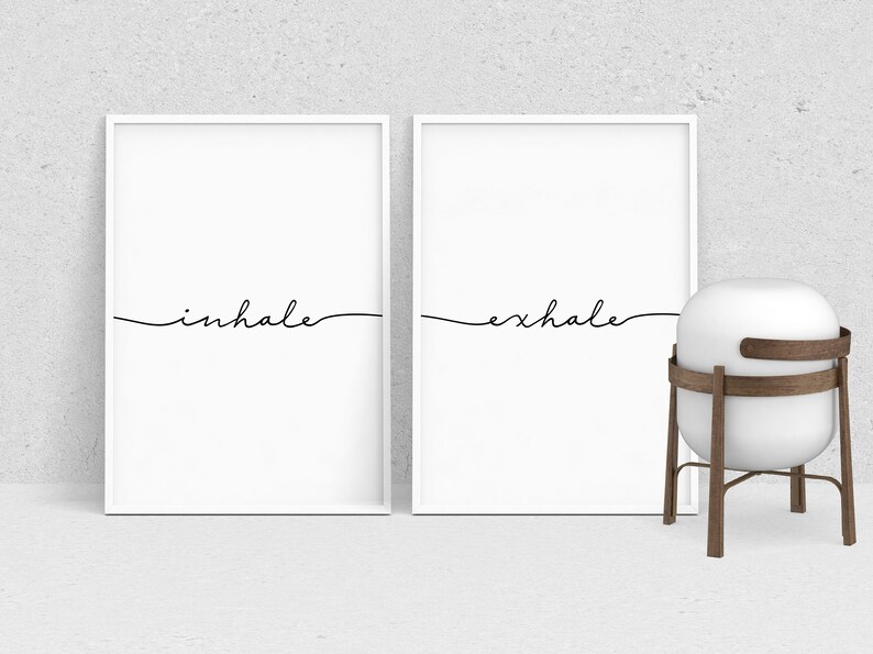 May include: Two white framed prints with black calligraphy. The left print says "inhale" and the right print says "exhale".