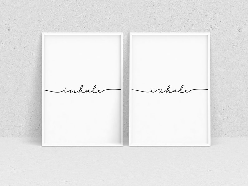 May include: Two white framed prints with black calligraphy. The left print says "inhale" and the right print says "exhale".
