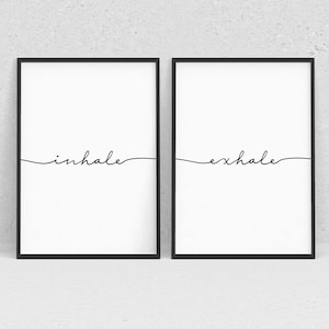 May include: Two black framed prints with white backgrounds. The left print has the word "inhale" written in cursive. The right print has the word "exhale" written in cursive.