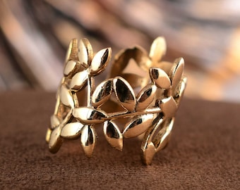 May include: Gold leaf ring with a delicate design of leaves and branches. The ring is made of metal and has a smooth finish.