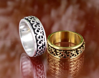 May include: Two silver and gold spinning rings with the Om symbol engraved around the band.