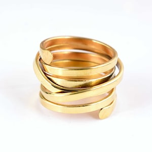 May include: A gold-toned ring with multiple bands twisted and wrapped around each other.