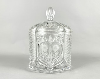 May include: A clear glass candy jar with a lid. The jar is decorated with an etched floral design and a heart shape.