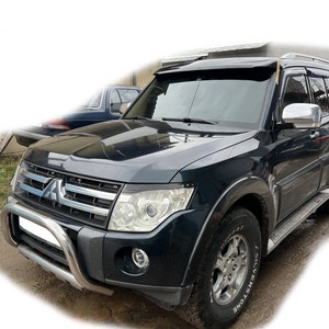 Puede incluir: Un SUV Mitsubishi Montero negro con un parachoques cromado, un portaequipajes de techo negro y un visor de parabrisas negro. El vehículo tiene una rueda plateada con un neumático negro que dice "Silverstone" en el lateral.