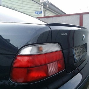 May include: A black BMW saloon with a rear spoiler, red tail lights, and a number plate that reads "CE 41885".