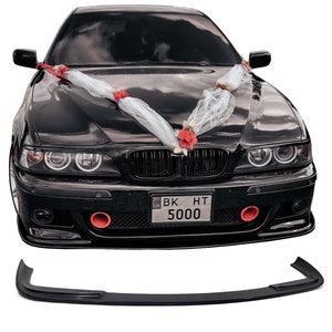 Könnte beinhalten: Ein schwarzer BMW 5er Limousine mit einem weißen und roten Blumengirlanden auf der Motorhaube. Das Auto hat eine schwarze Frontstoßstange mit einem schwarzen Nummernschild, auf dem "BK HT 5000" steht.