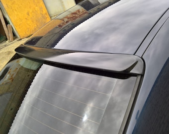 Könnte beinhalten: Ein schwarzes Auto mit einem schwarzen Heckspoiler. Der Spoiler ist ein kleiner, aerodynamischer Flügel, der an der Oberseite der Heckscheibe befestigt ist.