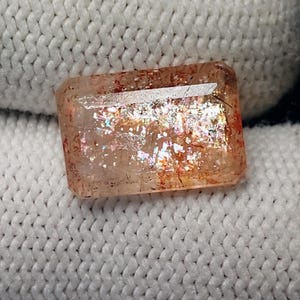 May include: A handmade wooden sign with the text "Welcome" in a whimsical font. The sign is painted white with a distressed finish, and features a decorative floral design in shades of pink and green. It measures approximately 12 inches wide.