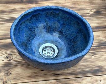 May include: A blue ceramic sink with a silver drain.