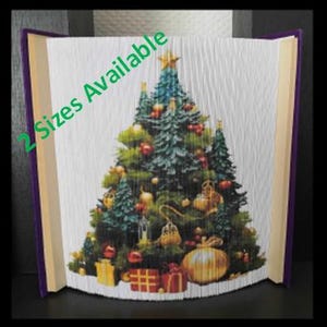 May include: A book art sculpture of a Christmas tree with ornaments and presents. The book is folded into a 3D shape and the cover is purple. The text "2 Sizes Available" is on the cover.