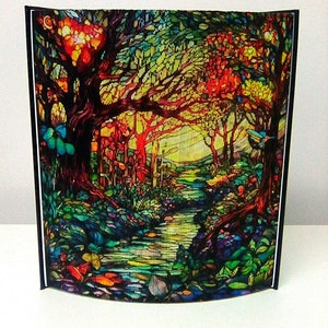 May include: A stained glass style image of a forest scene with a path leading through the trees. The image is dominated by shades of green, blue, and red, with a hint of yellow in the background.