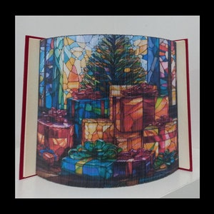 以下が含まれることがあります： クリスマスツリーとプレゼントを表現した本の芸術彫刻。彫刻は本の折り畳まれたページで作られており、ページはステンドグラスのデザインで描かれています。彫刻は、ホリデーシーズンを祝うユニークで創造的な方法です。