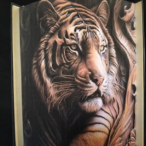 May include: A close-up of a tiger's face, with intricate details created using folded pages of a book. The tiger's fur is a mix of brown, orange, and black, and its eyes are a piercing green. The background is a dark brown, with a hint of gold.