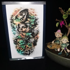 May include: A temporary tattoo featuring a colorful skull and floral design with a woman's face peeking out from behind the flowers.