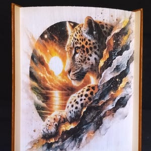 May include: A book art sculpture of a leopard with a sunset and starry sky background. The sculpture is made from folded pages of a book.