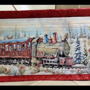 May include: A red and green train engine with a passenger car pulls through a snowy winter scene. The train is decorated with red and green holly and berries. The scene is painted on a book cover.