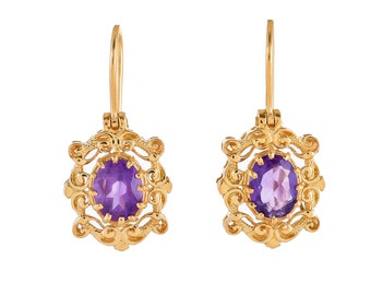 May include: A pair of gold earrings with a purple amethyst gemstone in each. The earrings have a delicate, ornate design.