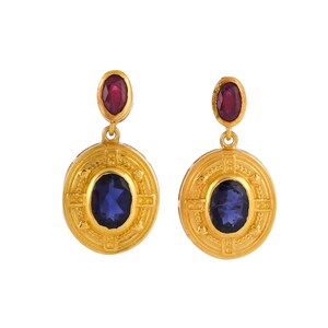 May include: Gold earrings with a blue oval gemstone surrounded by a circular design and a red oval gemstone hanging from the top.