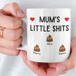 May include: White ceramic mug with the text "Mum's Little Shits" and three poop emojis with the names "Alfie", "Harry", and "Sophia" underneath.