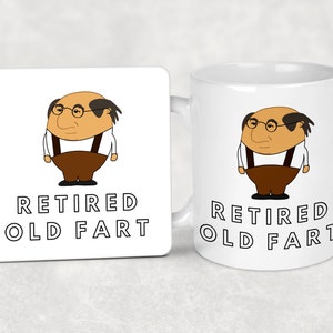 K&ouml;nnte beinhalten: Ein wei&szlig;er Becher und ein passender Untersetzer mit einer Cartoon-Illustration eines &auml;lteren Mannes mit Brille und Hosentr&auml;gern. Der Text "RETIRED OLD FART" ist unter dem Bild auf beiden Artikeln aufgedruckt.