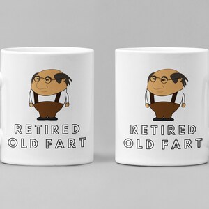 K&ouml;nnte beinhalten: Zwei wei&szlig;e Keramikbecher mit einer Cartoon-Illustration eines Mannes mit Brille, Hosentr&auml;gern und brauner Hose. Der Text "RETIRED OLD FART" ist unter der Illustration aufgedruckt.