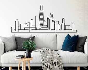 Könnte beinhalten: Ein weißes Sofa mit schwarzen und blauen Kissen, einer schwarz-weißen Musterdecke und einem kleinen Holz-Beistelltisch. Im Hintergrund steht eine schwarze Stehlampe. An der Wand hinter dem Sofa ist eine schwarz-weiße Skyline einer Stadt zu sehen.