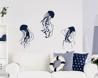 May include: A white couch with blue and white striped pillows and a life preserver pillow. The wall behind the couch has three dark blue jellyfish silhouettes.