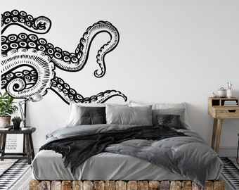 May include: Black and white octopus wall decal with tentacles wrapping around a gray bed with black throw pillows and a black blanket. The bed has a wooden frame and is sitting on a patterned rug.