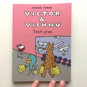 Può includere: Una copertina di libro con il titolo "VICTOR & VISHNU" in grandi lettere bianche su sfondo rosa. L'illustrazione raffigura due personaggi dei cartoni animati, un'anatra e un orso, in un aeroporto, che trasportano borse della spesa. Il testo "Text free" è visibile.