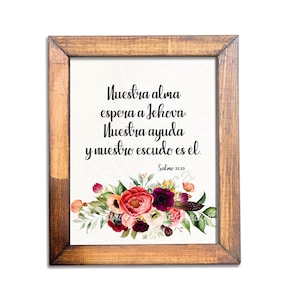 May include: A framed print with a wooden frame. The print features the text "Nuestra alma espera a Jehova, Nuestra ayuda y nuestro escudo es el. Salmo 33:20" above a floral arrangement of red, pink, and purple flowers with green leaves.