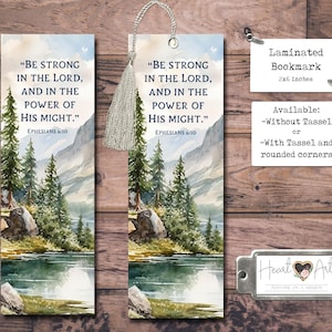 May include: Laminated bookmark with a watercolor landscape design featuring a lake, trees, and mountains. The bookmark includes the text "BE STRONG IN THE LORD, AND IN THE POWER OF HIS MIGHT." It measures 2x6 inches.