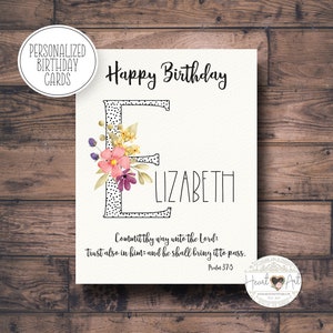 May include: A personalized birthday card with the name "Elizabeth" in a handwritten font. The letter "E" is decorated with a floral design. The card includes the text "Happy Birthday" and a Bible verse.