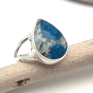 Peut inclure: Une bague en argent avec une pierre pr&eacute;cieuse bleu et blanc en forme de larme.