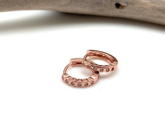 Pendientes Huggie de oro rosa y aros pequeños de plata de ley