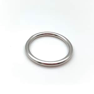 May include: A simple silver ring with a smooth, rounded surface.