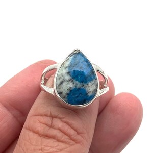 Peut inclure: Une bague en argent avec une pierre pr&eacute;cieuse bleu et blanc en forme de larme.