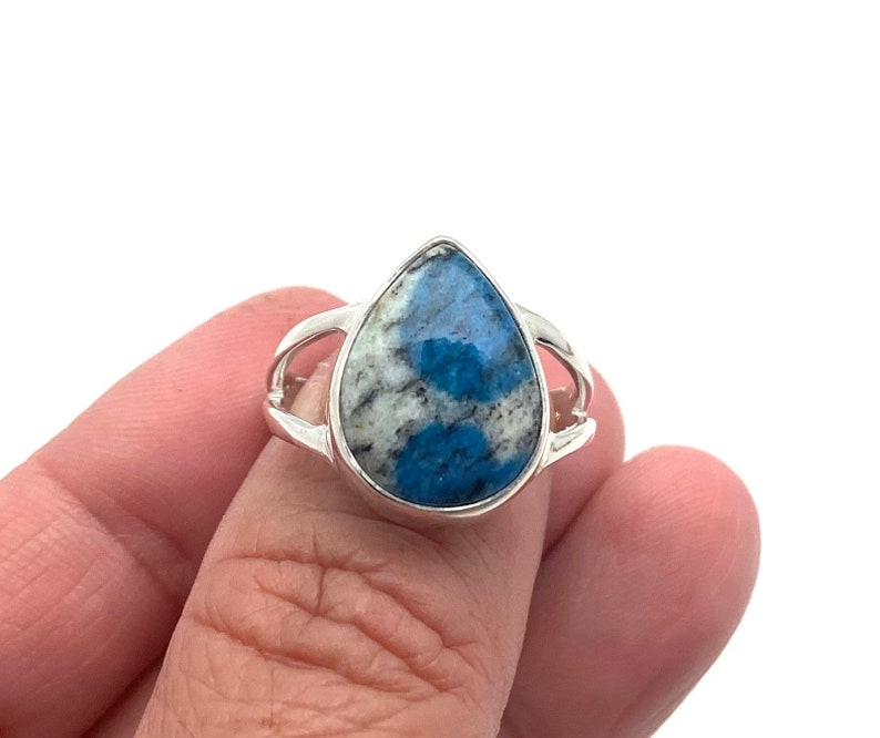 Peut inclure: Une bague en argent avec une pierre pr&eacute;cieuse bleu et blanc en forme de larme.