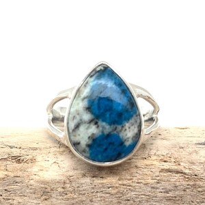 Peut inclure: Une bague en argent avec une pierre pr&eacute;cieuse bleu et blanc en forme de larme.