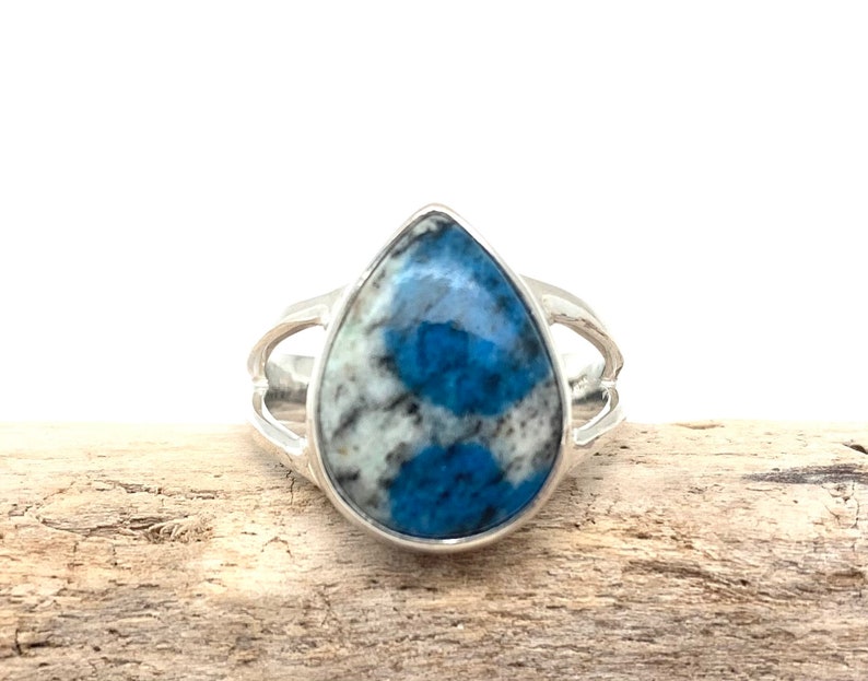 Peut inclure: Une bague en argent avec une pierre pr&eacute;cieuse bleu et blanc en forme de larme.