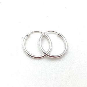 May include: A pair of silver hoop earrings. The hoops are simple and classic, with a smooth finish.