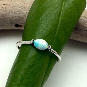 May include: A white ceramic mug with a black handle and the text "But First, Coffee" in a black, bold font. The mug is on a white surface.