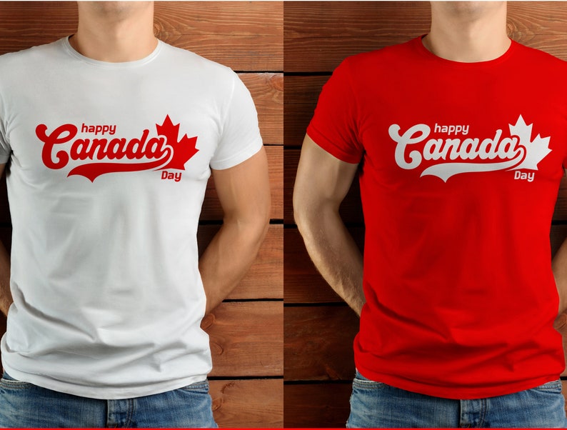 K&ouml;nnte beinhalten: Zwei T-Shirts mit dem Text "happy Canada Day" in rot-wei&szlig;er Schrift mit einem roten Ahornblatt-Motiv. Das T-Shirt links ist wei&szlig; und das T-Shirt rechts ist rot.